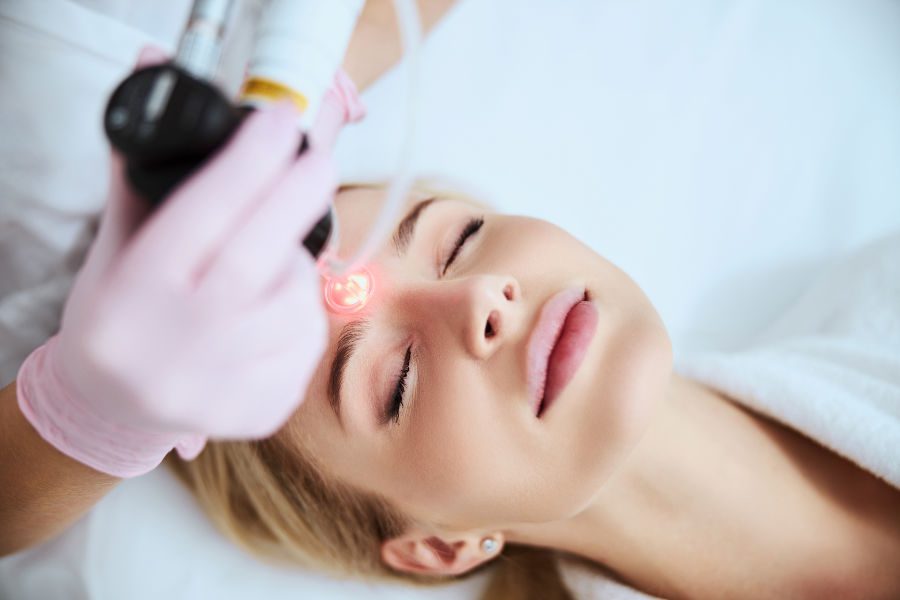 Tranquil female patient lying with closed eyes during the laser treatment
